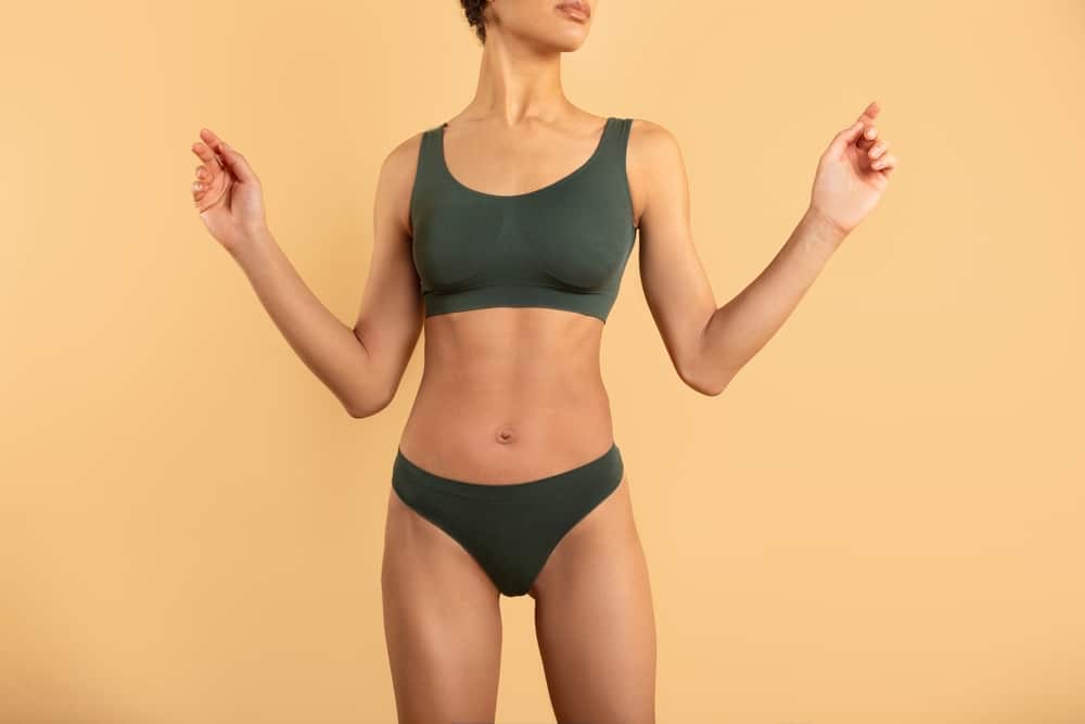 Fit,Sporty,Lady,In,Underwear,Posing,Over,Beige,Studio,Background,